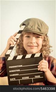 Kid holding clapper board in hands. Cinema concept. Retro style