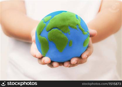 kid holding the clay globe in hand