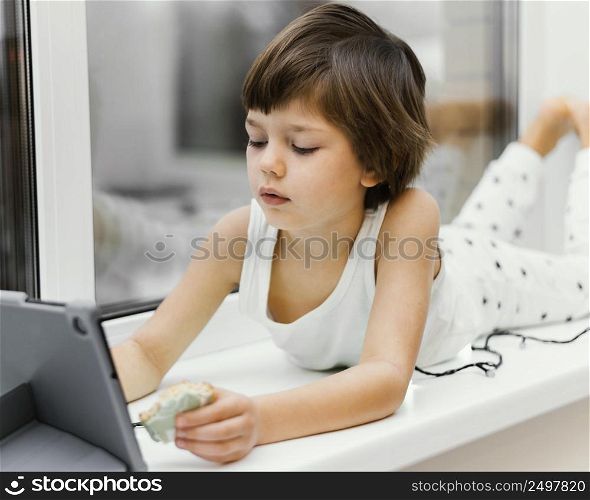 kid indoors looking tablet