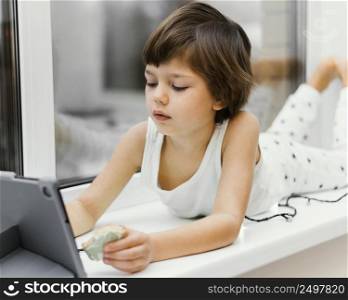 kid indoors looking tablet