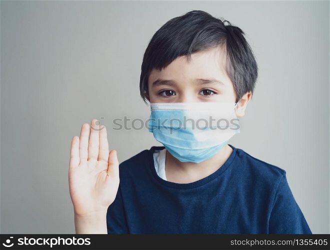 Kid isolation wearing medical protection face mask show stop gesture with his hand,Child to stay at home during corona virus home quarantine,Protective measures against spreading of Covid-19 lock down