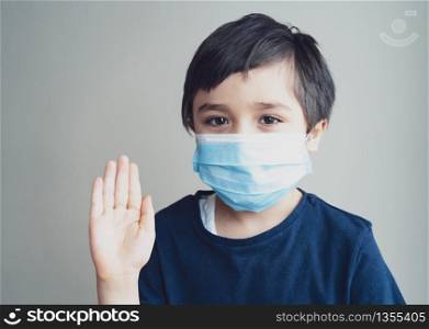 Kid isolation wearing medical protection face mask show stop gesture with his hand,Child to stay at home during corona virus home quarantine,Protective measures against spreading of Covid-19 lock down