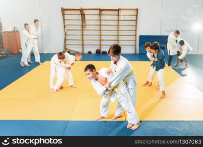 Kid judo, childrens training martial art, self-defense. Little boys in uniform in sport gym, young fighters