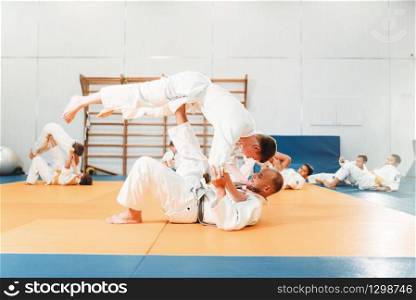 Kid judo, young fighters on training. Little boys in kimono practice martial art in sport hall