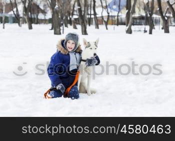 Kid of school age with dog in winter park. My best friend and I