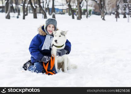 Kid of school age with dog in winter park. My best friend and I