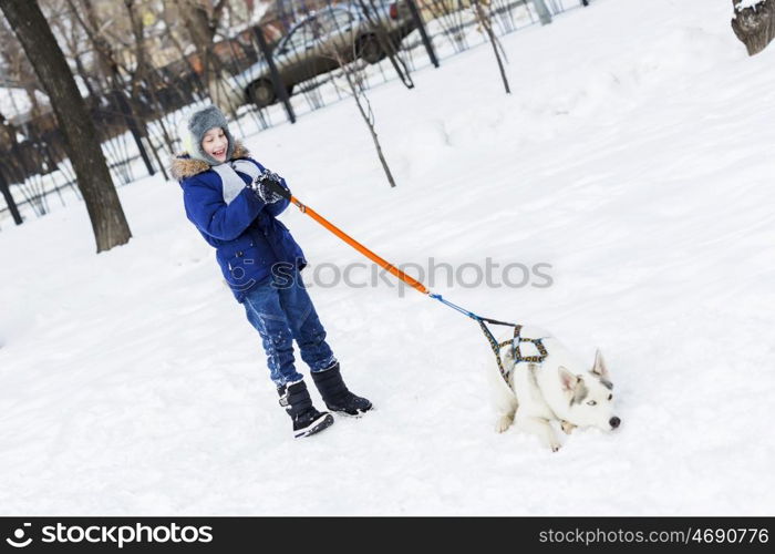 Kid of school age with dog in winter park. My best friend and I