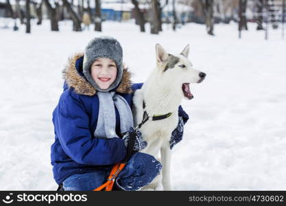 Kid of school age with dog in winter park. My best friend and I