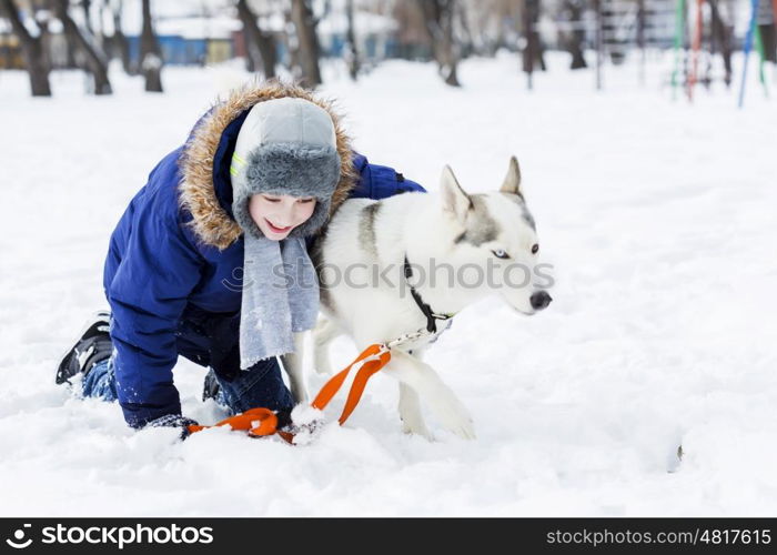 Kid of school age with dog in winter park. My best friend and I