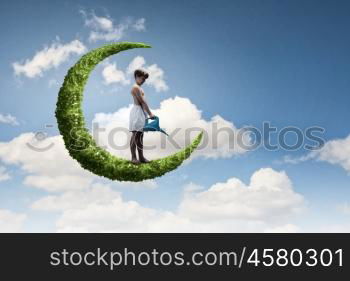 Kid on moon. Little boy standing on moon with can in hands