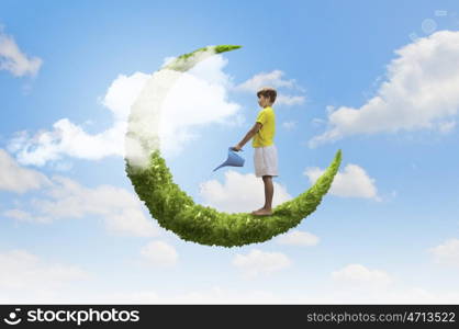 Kid on moon. Little boy standing on moon with can in hands