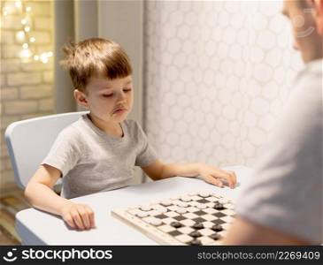kid playing chess with man
