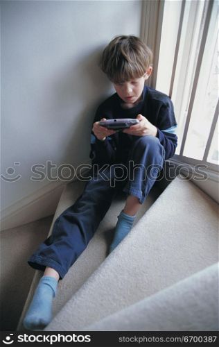 kid playing video game on the staircase