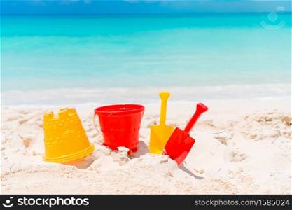 Kid&rsquo;s beach toys, hat and sunglasses on white sandy beach background the sea. Beach kid&rsquo;s toys on white sand beach