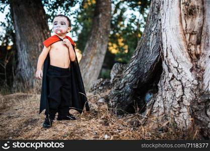 Kid serious costumed of dracula to halloween on the forest