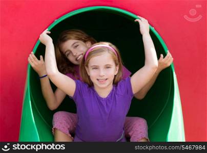 kid sister girls playing in the park playground tunnel