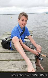 Kid sitting on a pontoon with fishing rod