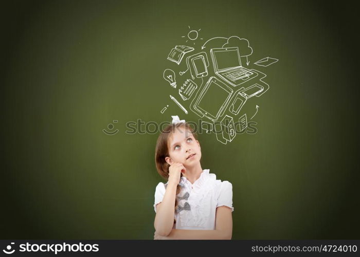 Kid student girl against school blackboard having good idea. Thoughtful girl standing at blackboard