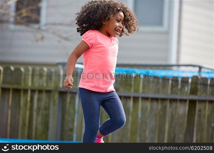 Kid toddler girl jumping on a playground in the backyard latin ethnicity