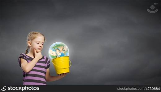 Kid with bucket. Cute girl looking at Earth planet in her bucket. Elements of this image are furnished by NASA