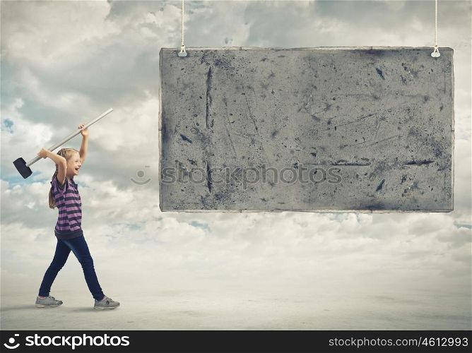 Kid with hammer. Cute little girl crushing cement banner with hammer