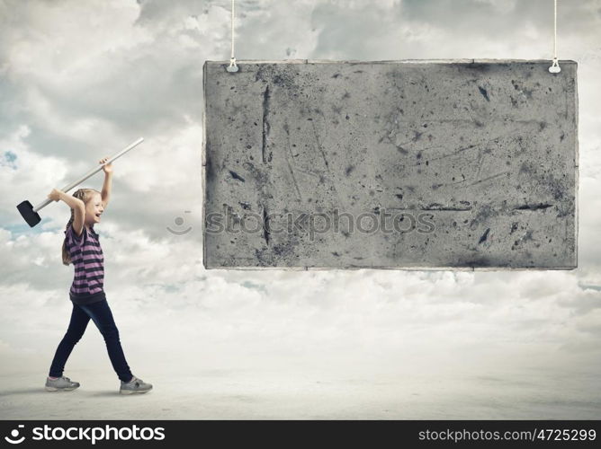 Kid with hammer. Cute little girl crushing cement banner with hammer