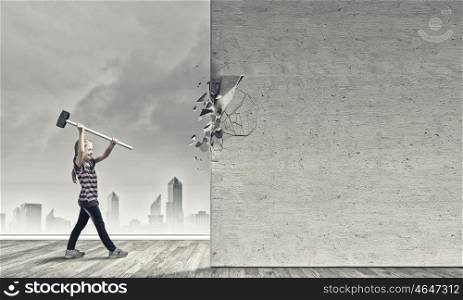 Kid with hammer. Cute little girl crushing cement wall with hammer