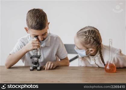 kid with medical mask looking through microscope