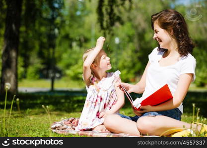 Kid with mom. Image of cute girl and her mother playing in park