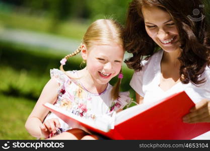 Kid with mom. Image of cute girl and her mother playing in park