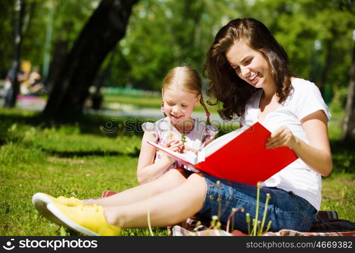 Kid with mom. Image of cute girl and her mother playing in park