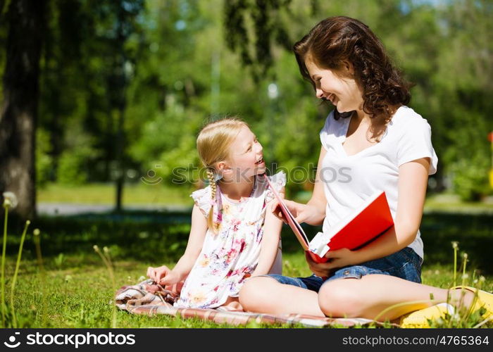 Kid with mom. Image of cute girl and her mother playing in park