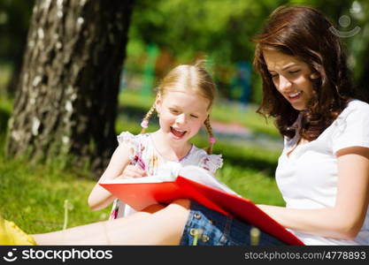 Kid with mom. Image of cute girl and her mother playing in park