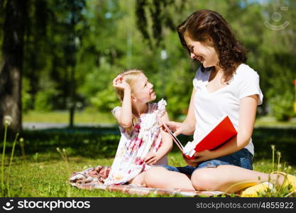 Kid with mom. Image of cute girl and her mother playing in park