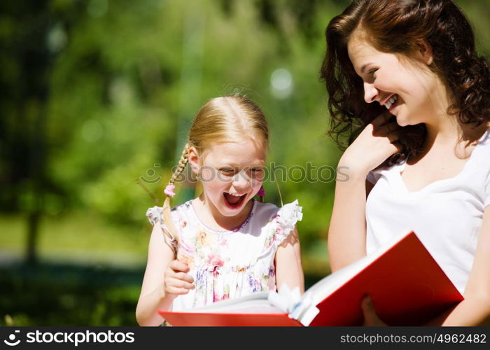 Kid with mom. Image of cute girl and her mother playing in park