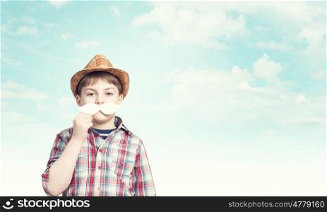 Kid with mustache. Cute boy wearing shirt and paper mustache