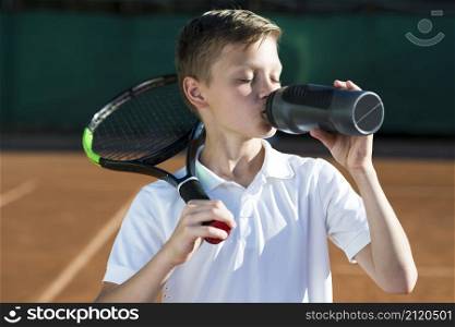 kid with racket shoulder drinking water