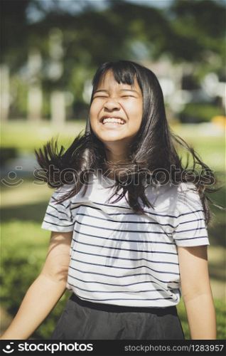 kidding face of asian teenager showns forelock hair flowing by wind