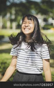 kidding face of asian teenager showns forelock hair flowing by wind