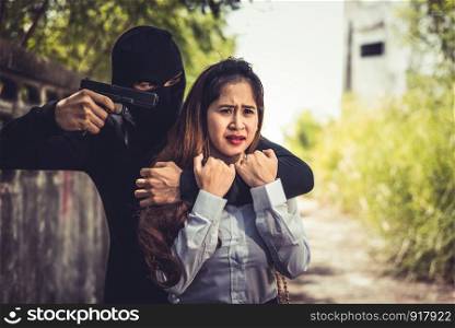 Kidnapper or Robber force knifepoint woman hostage to take off her clothes or steal her money at outdoors road. Raping sexual and Criminal theme. Social issues and problem concept