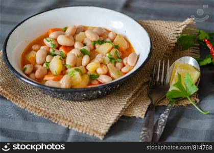Kidney beans in tomato sauce with carrot in a white bowl, closeup. horizontal view from above