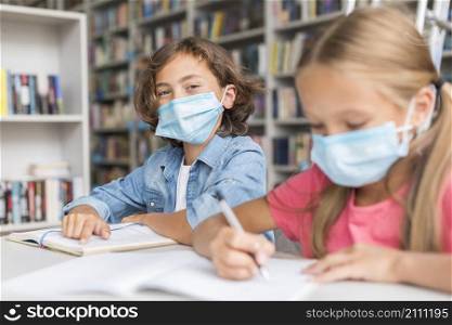 kids doing homework while wearing medical masks