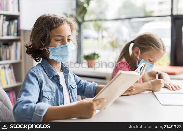 kids doing their homework while wearing face mask