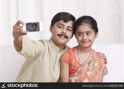 Kids dressed as husband and wife taking a self portrait