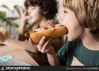 kids eating hot dogs together