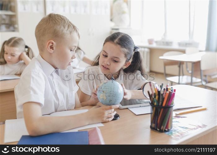 kids examining globe lesson