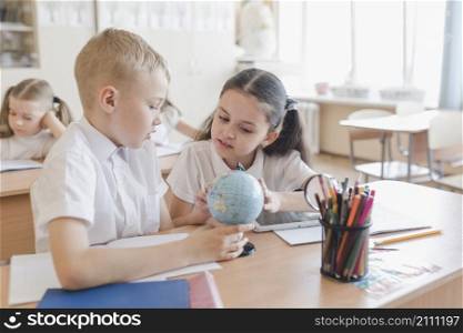 kids examining globe lesson