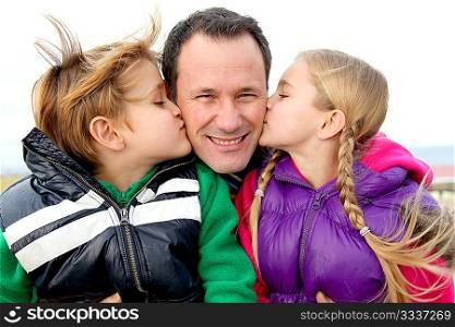Kids giving a kiss to their daddy
