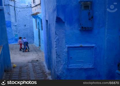Kids in Chefchaouen, the blue city in the Morocco.. Chefchaouen, the blue city in the Morocco is a popular travel destination