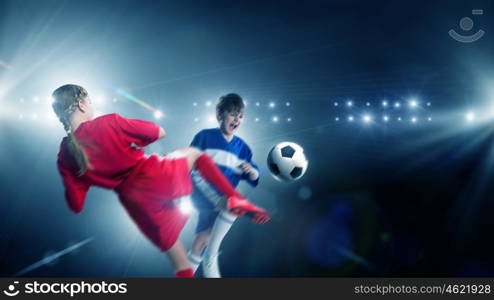 Kids play soccer on stadium . Kid boy and girl on soccer stadium fighting for ball